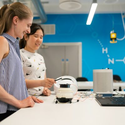 woman in white and black polka dot shirt holding white headphones